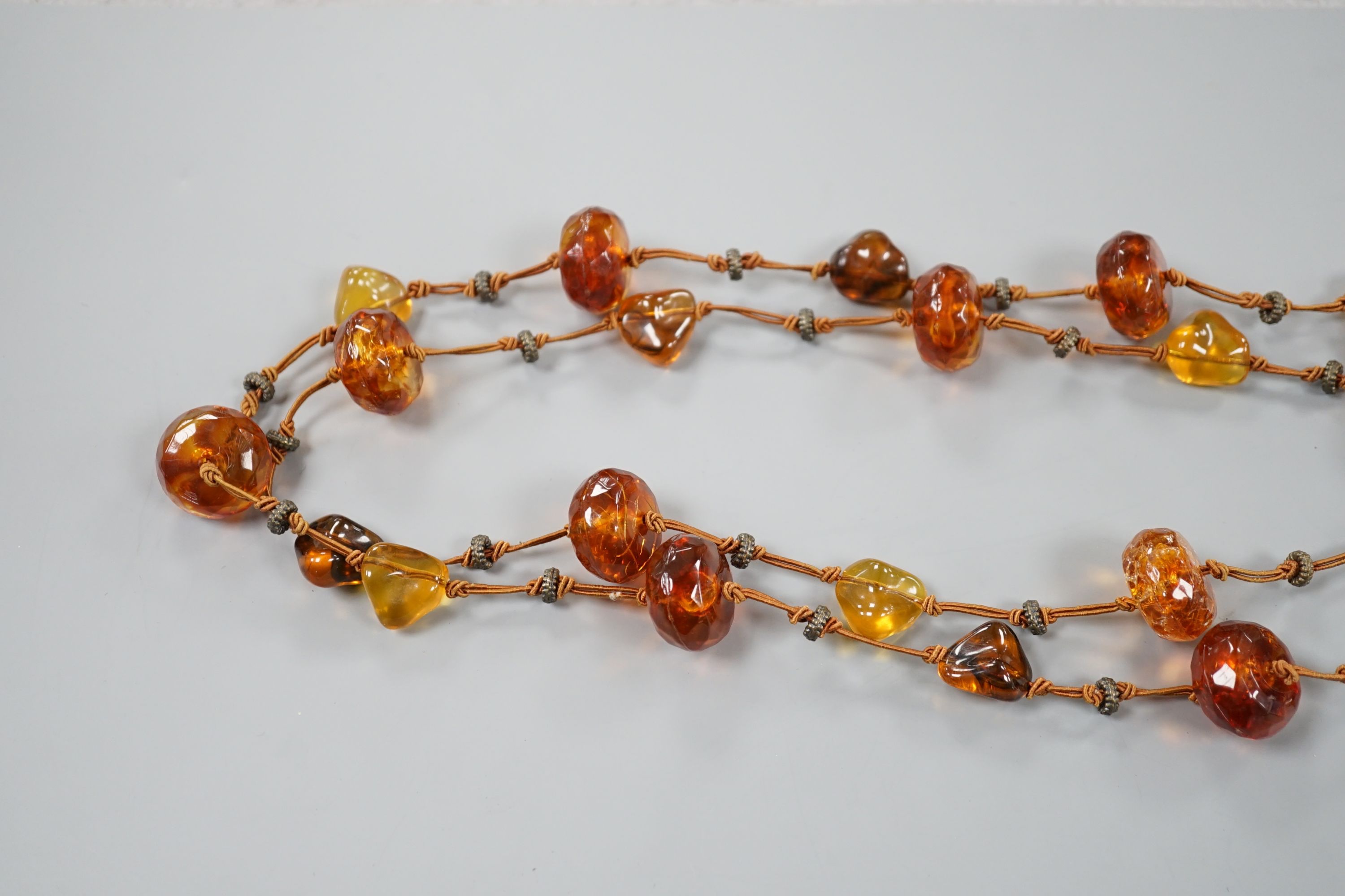 A single strand facetted and pebble amber necklace, 138cm.